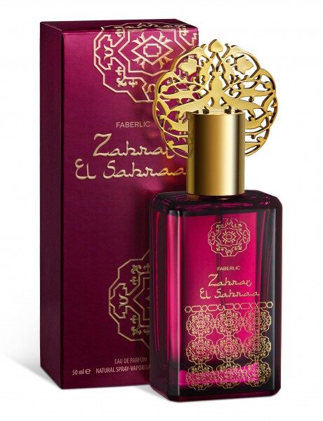 Купить Парфюм Faberlic Zahra el Sahraa в бордовом флаконе с золотой крышкой и восточным орнаментом стоит рядом с фирменной коробкой. из каталога Фаберлик.